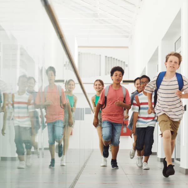 Upper grade school children running down the school hallway